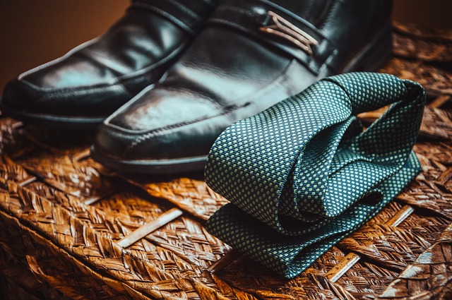 Mužské topánky a kravata položené na hnedom podklade.jpg